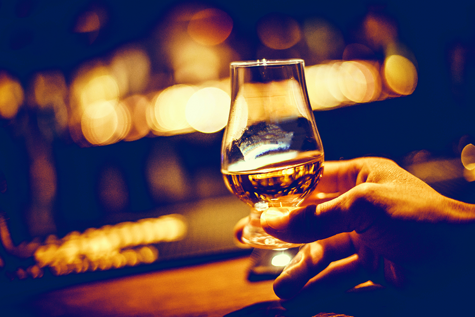Hand holding a Glencairn single malt whisky glass